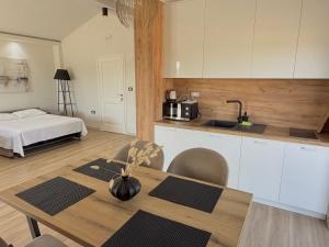 a kitchen and dining room with a table and a bed at Apartments Lj in Ulcinj