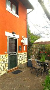 an orange building with a table and an umbrella at La Dolce Casa Centre Free Parking Family in Celano
