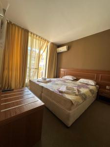 a bedroom with a large bed and a window at Hotel AVALON in Nesebar +40 photos