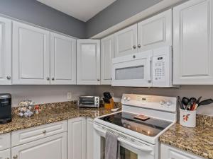 a kitchen with white cabinets and a stove top oven at Crescent Beauty in Myrtle Beach
