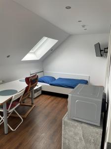 a bedroom with a bed and a desk and a table at Ferienzimmer Saarlouis in Saarlouis