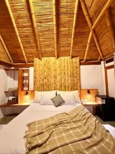 a large bed in a room with a wooden ceiling at Hotel Puerto Antiguo in Los Órganos