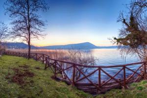 a wooden fence next to a body of water at La Dimora Dei Cimini in Caprarola