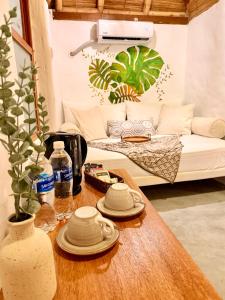 a table with plates and cups on it in a living room at Hotel Puerto Antiguo in Los Órganos