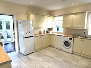 a kitchen with a refrigerator and a washing machine at White Lion Aberporth in Aberporth