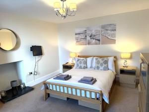 a bedroom with a bed with two tables and a mirror at White Lion Aberporth in Aberporth