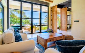 a living room with large windows and a table at Tombolo Bay in Dickwella