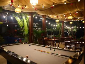 a pool table in front of a restaurant with lights at Thach's Homestay Tam Coc in Vũ Lâm