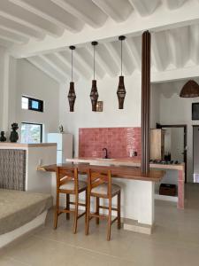a kitchen with a wooden table and some lights at Departamento in Lo de Marcos