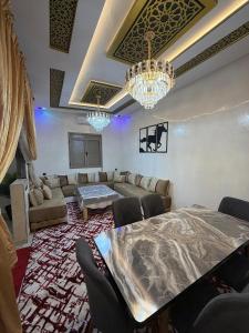 a living room with a couch and a table and chandeliers at Merzouga Desert Apartment in Merzouga