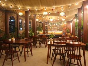 a restaurant with wooden tables and chairs and lights at Thach's Homestay Tam Coc in Vũ Lâm