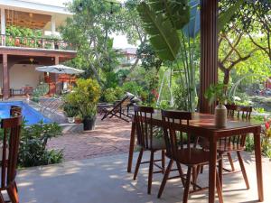 a table and chairs in a patio with a pool at Thach's Homestay Tam Coc in Vũ Lâm