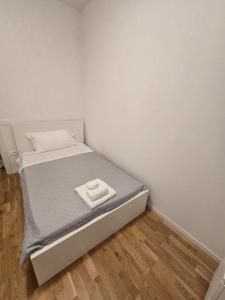 a bed in a room with a white wall at Appartamento Saffi in Faenza