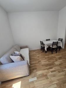 a living room with a couch and a table at Appartamento Saffi in Faenza +2 photos