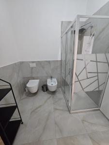 a bathroom with a toilet and a shower and a sink at Appartamento Saffi in Faenza