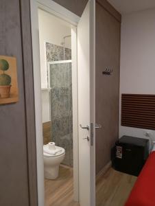a bathroom with a toilet and a glass shower door at Borgo Mantova in Potenza +6 photos
