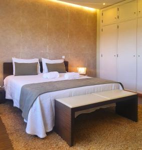 a bedroom with a large bed and a table at CAS Living Fátima in Fátima