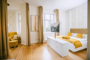 a white bedroom with a bed and a chair at Johanniterhaus Wittenberg in Lutherstadt Wittenberg