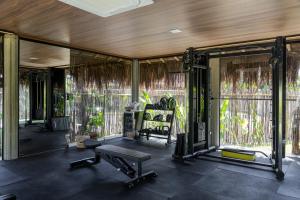 ein Fitnessstudio mit einer Bank und einem Stuhl in einem Raum in der Unterkunft Evva Pousada in Pôrto de Pedras