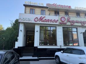 a white car parked in front of a store at Monroe Hotel in Almaty