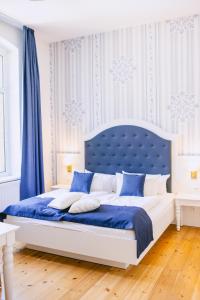 a blue and white bedroom with a large bed at Johanniterhaus Wittenberg in Lutherstadt Wittenberg