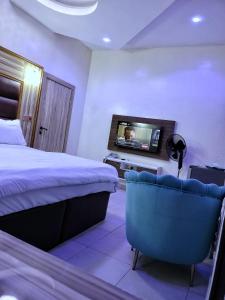 a hotel room with a bed and a flat screen tv at UG Apartment Lagos in Isagatedo