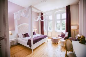 a bedroom with a canopy bed and a chair at Johanniterhaus Wittenberg in Lutherstadt Wittenberg