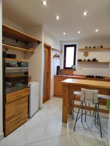 a kitchen with a wooden counter and a table and chairs at Apartmán 24 in Medzilaborce