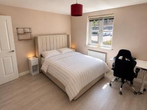 ein Schlafzimmer mit einem Bett, einem Schreibtisch und einem Stuhl in der Unterkunft Bright, Spacious Double Room in a Modern Flat in Edmonton