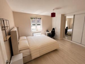 ein Schlafzimmer mit einem großen Bett und einem Fenster in der Unterkunft Bright, Spacious Double Room in a Modern Flat in Edmonton