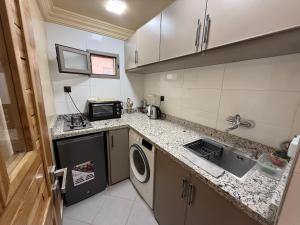 a small kitchen with a washer and dryer in it at Les Plamiers d'anis in Ouarzazate