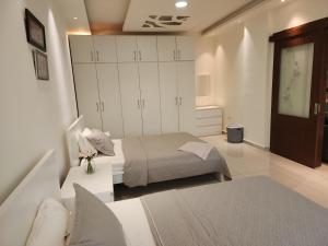 a small bedroom with a bed and a cabinet at Al-Amaari Gardens Compound 3091 in Irbid +29 photos