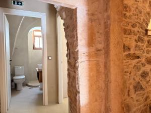 a bathroom with a stone wall and a toilet at Opus Luxury Maisonette in Chios