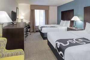 a hotel room with two beds and a desk at La Quinta by Wyndham Moscow Pullman in Moscow +21 photos