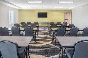 a conference room with tables and chairs and a screen at La Quinta by Wyndham Moscow Pullman in Moscow