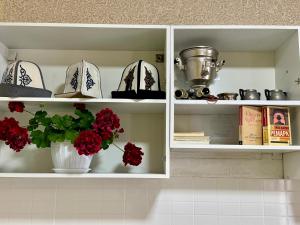 a white cabinet with a vase with red flowers in it at Ilgiz Guest House in Bokonbayevo
