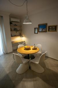 a dining room with a table and white chairs at Anastasios' artwork apartment in Thessaloniki