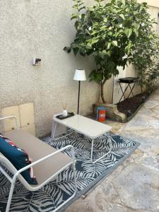 a table and chairs on a rug next to a tree at Coconning studio in Plauzat