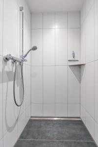 a shower in a white tiled bathroom at Ferienwohnung 2 Gasthaus Bußmann in Vreden