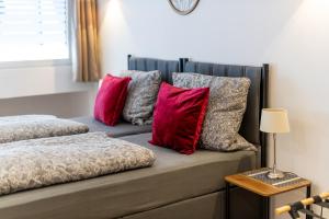 a couch with red and grey pillows on it at Ferienwohnung 2 Gasthaus Bußmann in Vreden