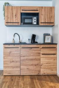 a kitchen with wooden cabinets and a microwave at Ferienwohnung 2 Gasthaus Bußmann in Vreden