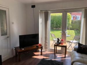 a living room with a flat screen tv and a couch at Koti in Murton