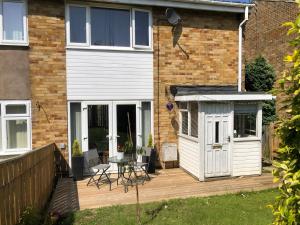 a house with a white shed on a wooden deck at Koti in Murton
