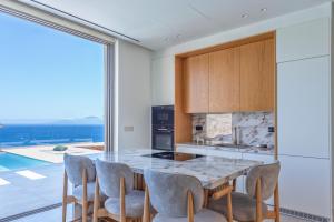 a kitchen with a table and chairs and a large window at Deciel Cave Villa in Áyios Pétros