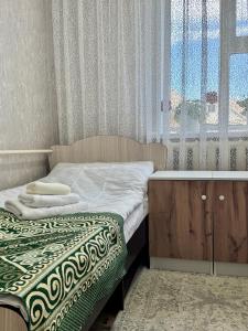 a small bedroom with a bed and a sink at Ilgiz Guest House in Bokonbayevo