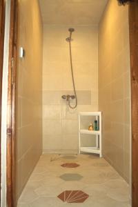 a shower in a bathroom with a tile floor at Surf & bask HOME in Tamraght Ouzdar