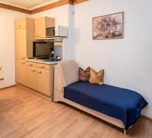 um pequeno quarto com uma cama e uma cozinha em Ferienwohnung Aschenwald em Ramsau im Zillertal