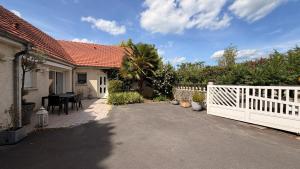 a house with a white fence and a driveway at Chez Delphine in Damery