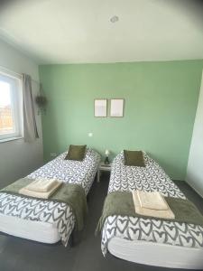 two beds sitting next to each other in a room at Villa Verano Apartamentos Compartidos Villaverde in La Oliva +20 photos