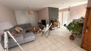 a living room with a couch and a table at Chez Delphine in Damery